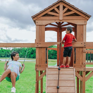 Backyard Discovery Sterling Point All Cedar Wooden Swing Set, Raised Clubhouse, Green Wave Slide, Web Swing, Climbing Wall, 10ft Wave Slide, 2 Belt Swings, Front Porch, Bridge